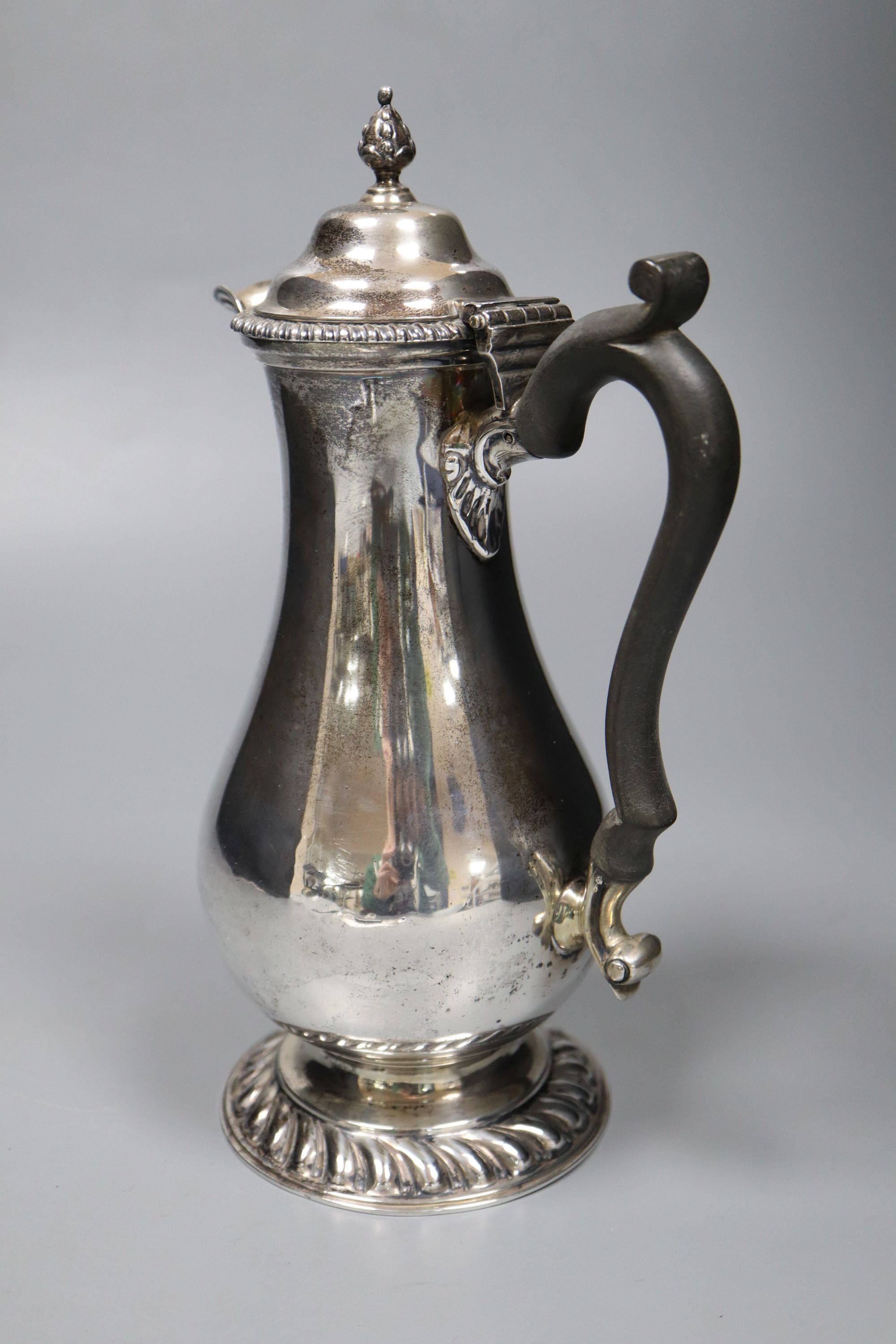 A George V silver baluster hot water pot, with ebonised handle, Goldsmiths & Silversmiths Co Ltd, London, 1927